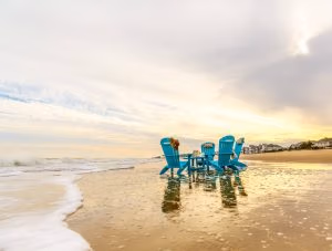 Four Aruba Blue Poly Adirondacks around Teal Blue Poly Coffee Table at the beach