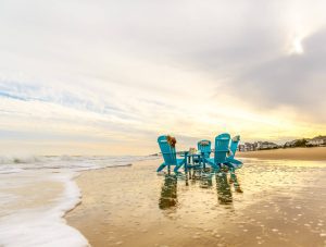 Four Aruba Blue Poly Adirondacks around Teal Blue Poly Coffee Table at the beach