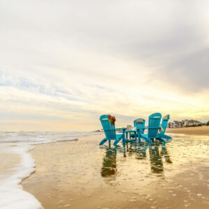 Four Aruba Blue Poly Adirondacks around Teal Blue Poly Coffee Table at the beach