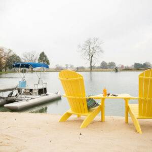 Two Yellow Poly Adirondack Chairs overlooking Lake