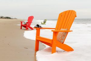 Poly Adirondack Chairs sitting in surf on the beach