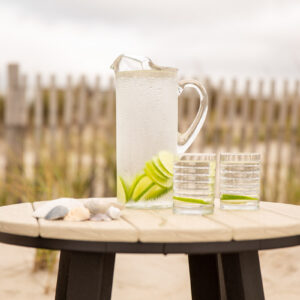 Poly Adirondack Table with lemonade pitcher on beach sand.