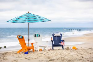 Poly Adirondack Chairs with an umbrella in ocean front setting.