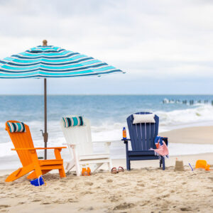 Poly Adirondack Chairs with an umbrella in ocean front setting.
