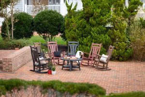 Poly porch rocking chairs set in a semi-circle on an outdoor patio.