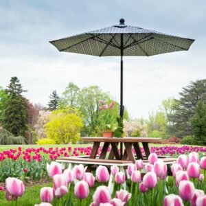 poly 48 inch round garden table with an umbrella and 40 inch curved garden benches in a tulip field