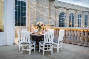 Eight white poly Keystone chairs around a table.