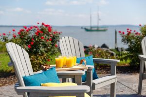 Two Great Bay Dining Chairs with a Great Bay Table Attachment on a dock by the ocean.