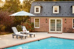 Poly poolside lounge chairs with side table and outdoor umbrella