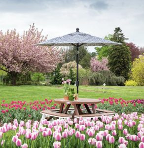 poly 48 inch round garden table with an umbrella and 40 inch curved garden benches in a tulip field