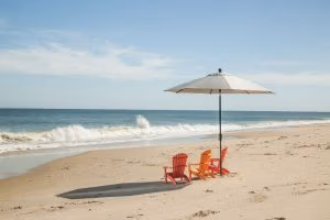 children's orange adirondacks on the beach