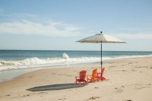 children's orange adirondacks on the beach