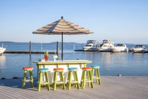 Striped outdoor umbrella with poly furniture bar and bar stools