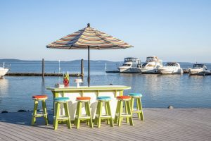 Striped outdoor umbrella with poly furniture bar and bar stools