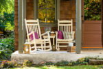 Two rockers sitting on a rustic cabin's porch.