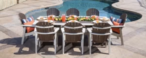 Great Bay Dining table and 8 chairs set up by a swimming pole with fruits and fruit punch on the table