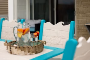 Finch Wave Chair and Table close up with sea turtle engraving on the chair back and a pitcher of water on the table
