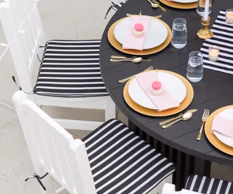 Close up shot of a black and white cushion on a white chair.