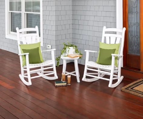 Two white rockers sitting on a front porch.