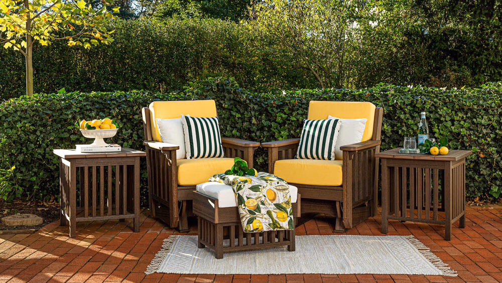 Two poly rockers sitting on a red brick patio with greenery in the background. 