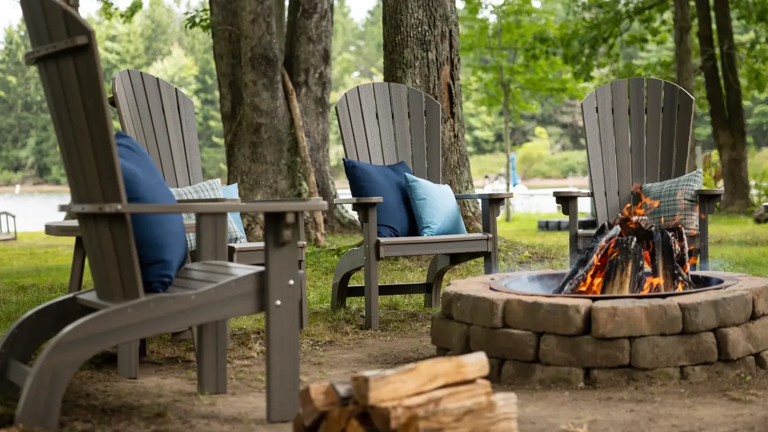 4 poly chairs sitting around a fire at a campground