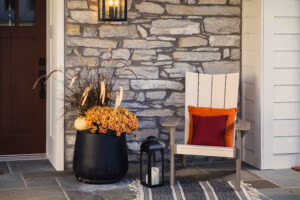 skyward poly patio furniture entryway chair with fall planter and stone wall